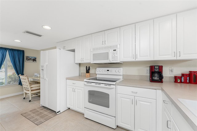 kitchen with light tile patterned flooring, white cabinets, and white appliances