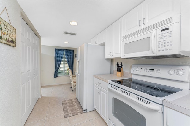 kitchen featuring light tile patterned flooring, white appliances, and white cabinets