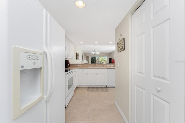 kitchen featuring sink, white appliances, white cabinetry, light tile patterned flooring, and kitchen peninsula