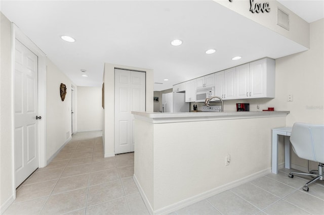 kitchen featuring white cabinetry, kitchen peninsula, refrigerator with ice dispenser, and light tile patterned floors