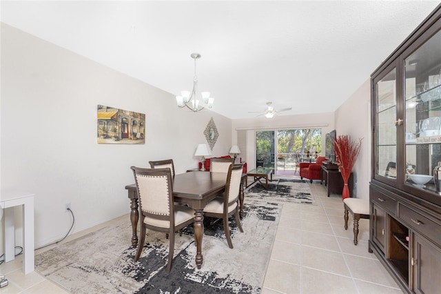 tiled dining space with ceiling fan with notable chandelier