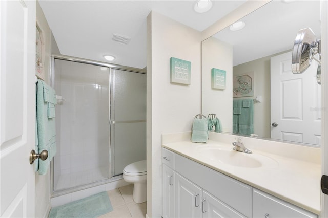 bathroom featuring tile patterned flooring, toilet, vanity, and a shower with shower door