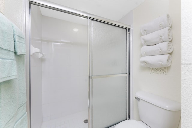 bathroom featuring an enclosed shower and toilet