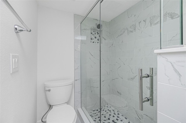 bathroom featuring toilet and a tile shower