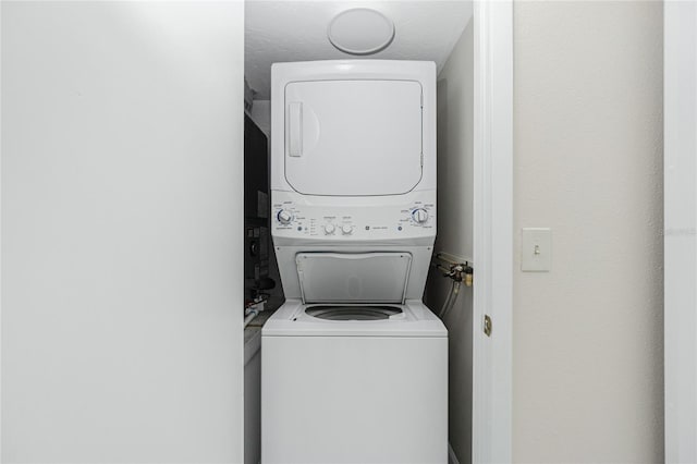 washroom featuring stacked washer / dryer