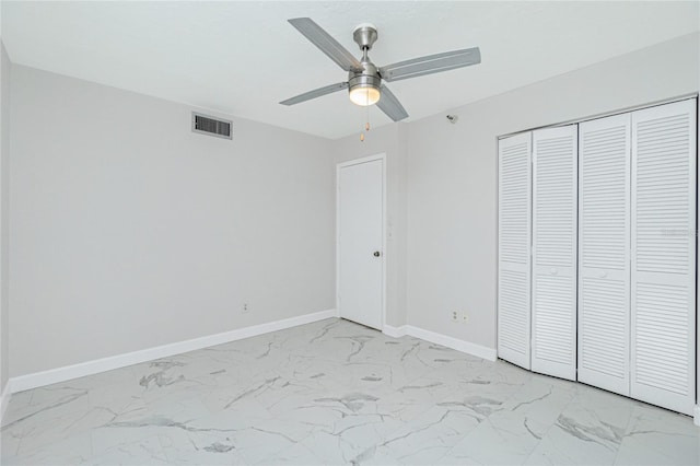 unfurnished bedroom with ceiling fan and a closet