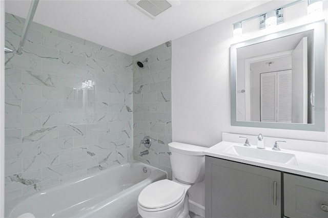 full bathroom with vanity, tiled shower / bath, and toilet