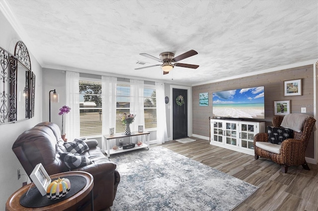 living room with hardwood / wood-style floors, ornamental molding, a textured ceiling, and ceiling fan