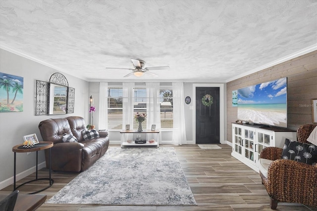 living room featuring hardwood / wood-style flooring, ornamental molding, ceiling fan, and a textured ceiling