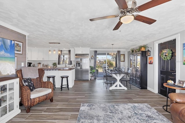 dining room with sink, dark wood-type flooring, ornamental molding, and a textured ceiling