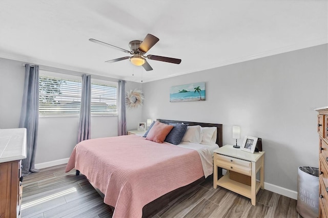 bedroom featuring ceiling fan, ornamental molding, and wood-type flooring