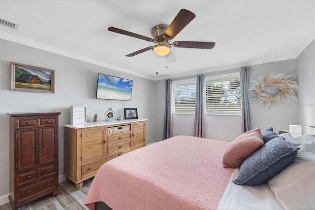 bedroom with crown molding, ceiling fan, and wood-type flooring