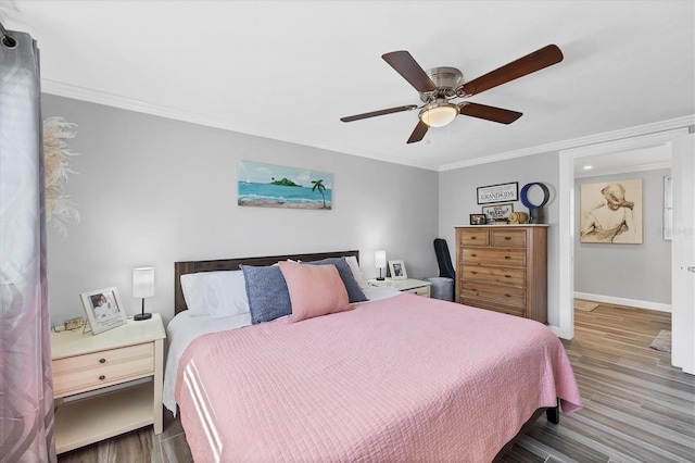 bedroom with crown molding, ceiling fan, and wood-type flooring