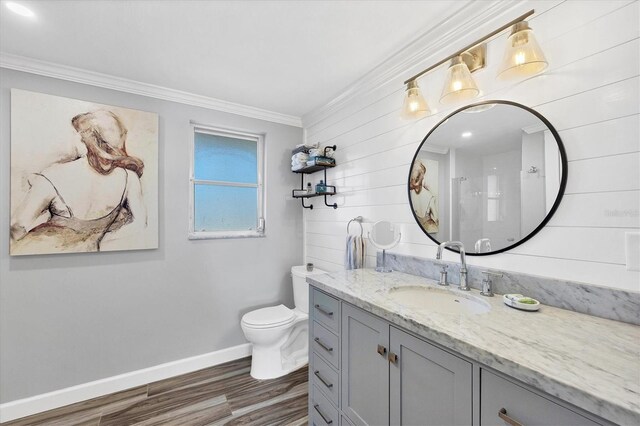 bathroom featuring a shower, hardwood / wood-style flooring, vanity, toilet, and crown molding