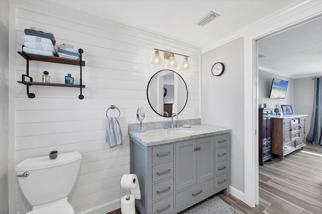 bathroom with ornamental molding, toilet, and vanity