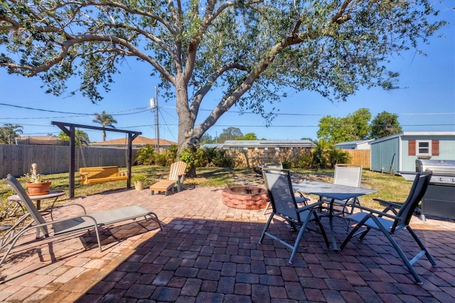 view of patio / terrace with a storage shed and an outdoor fire pit