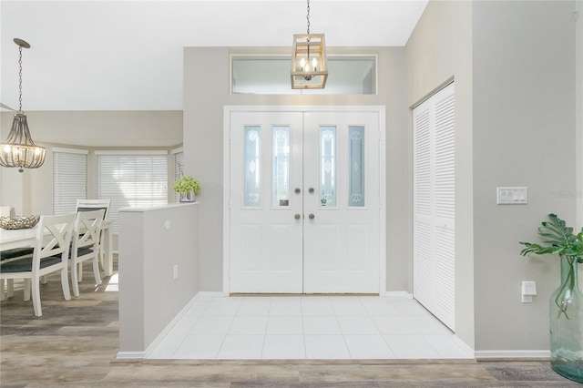 entrance foyer with light hardwood / wood-style flooring and a notable chandelier