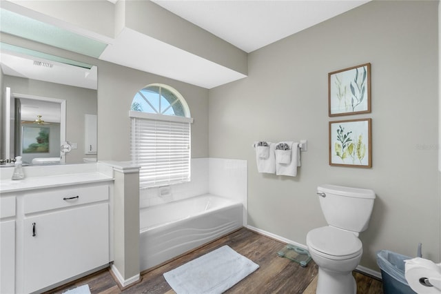 bathroom featuring hardwood / wood-style flooring, vanity, toilet, and a bathing tub