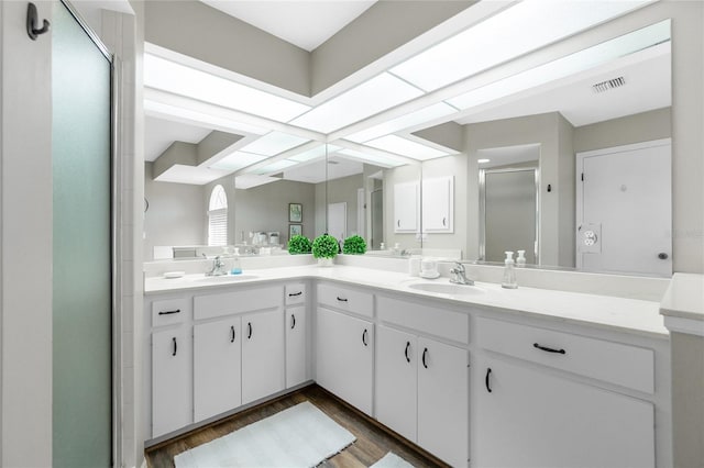 bathroom featuring hardwood / wood-style flooring, vanity, and an enclosed shower