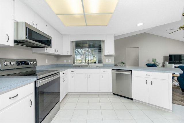 kitchen with appliances with stainless steel finishes, white cabinetry, sink, ceiling fan, and kitchen peninsula