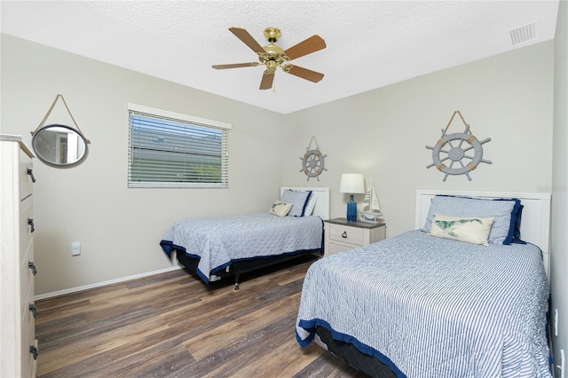 bedroom with ceiling fan, dark wood-type flooring, and a textured ceiling