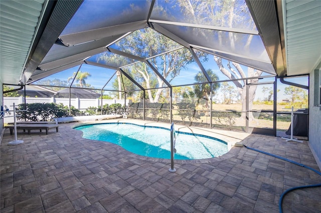 view of pool featuring glass enclosure and a patio area