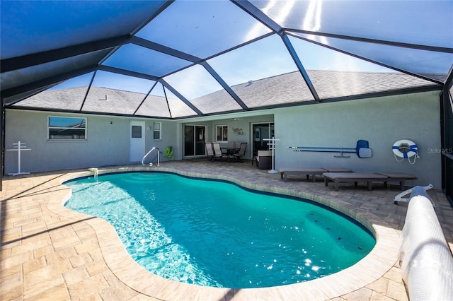 view of swimming pool with glass enclosure and a patio area