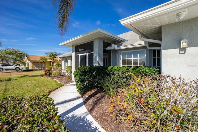 doorway to property featuring a lawn