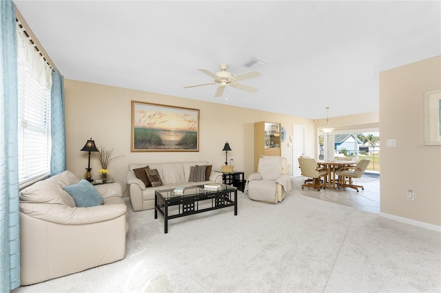 living area with light carpet, baseboards, visible vents, and a ceiling fan