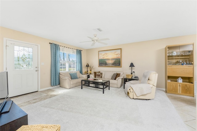 tiled living room with a ceiling fan, carpet, visible vents, and baseboards