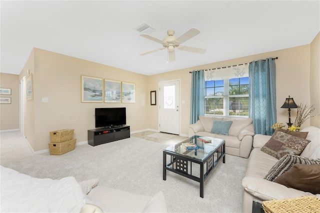 living area with light carpet, baseboards, visible vents, and a ceiling fan