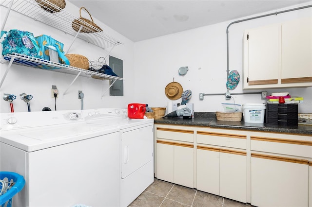 washroom featuring washing machine and dryer, cabinet space, and light tile patterned floors