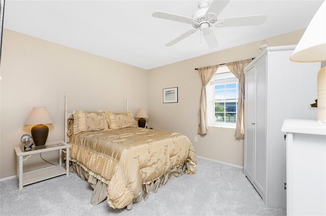 bedroom with light carpet, ceiling fan, and baseboards