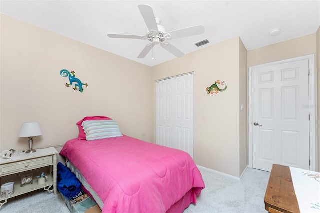 bedroom with ceiling fan, light colored carpet, visible vents, baseboards, and a closet