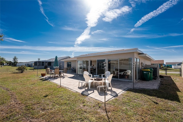 rear view of house with a patio and a yard