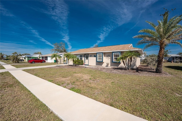 ranch-style home with concrete driveway, a front lawn, and stucco siding