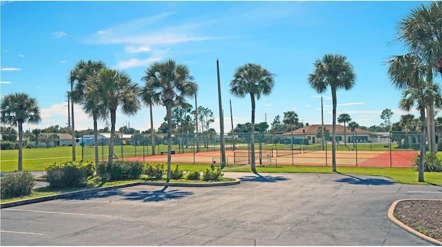 view of property's community featuring uncovered parking, fence, and a gate