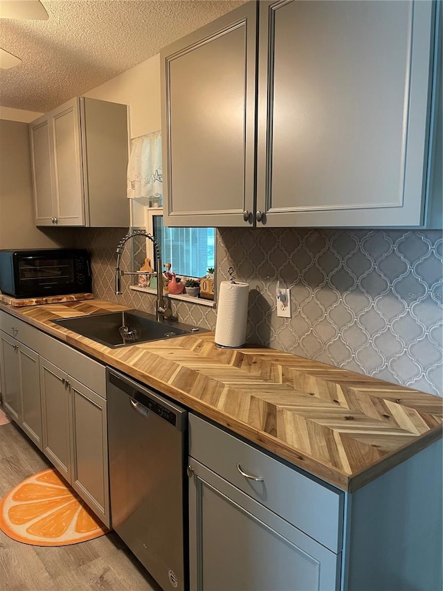 kitchen with sink, stainless steel dishwasher, and gray cabinetry