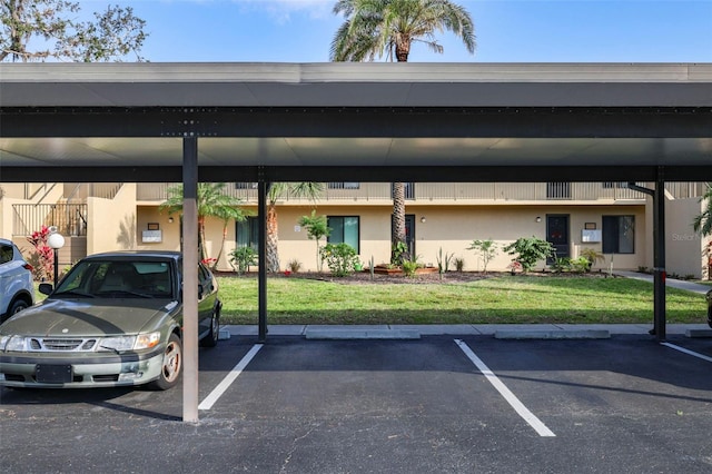 view of parking / parking lot with a carport and a lawn