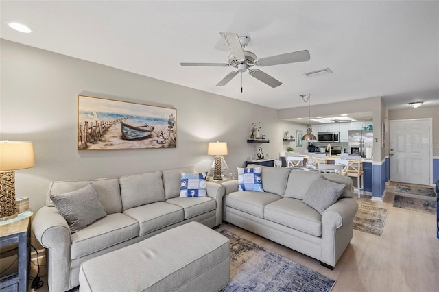 living room featuring hardwood / wood-style flooring and ceiling fan