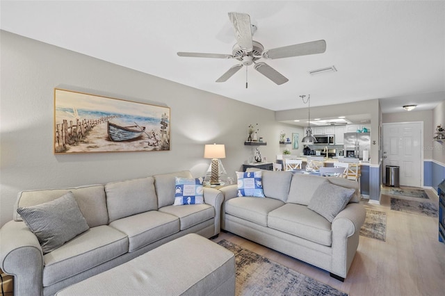 living room featuring hardwood / wood-style flooring and ceiling fan