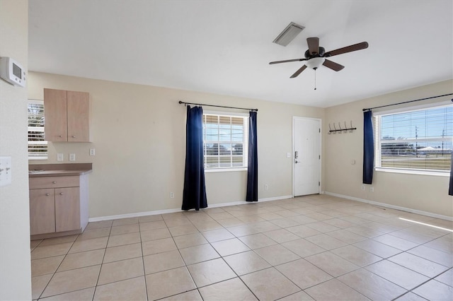 tiled spare room featuring a healthy amount of sunlight and ceiling fan