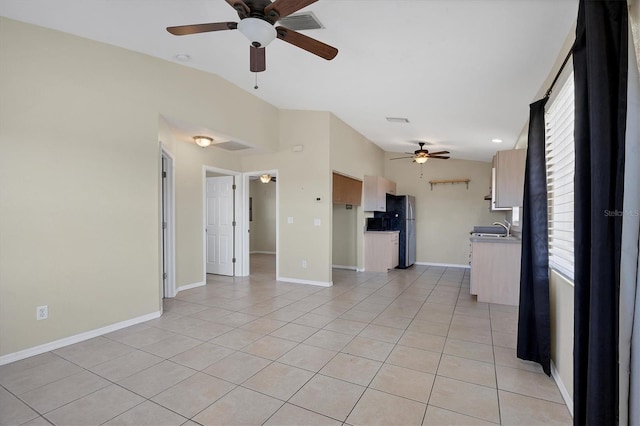 unfurnished living room with vaulted ceiling, ceiling fan, sink, and light tile patterned floors