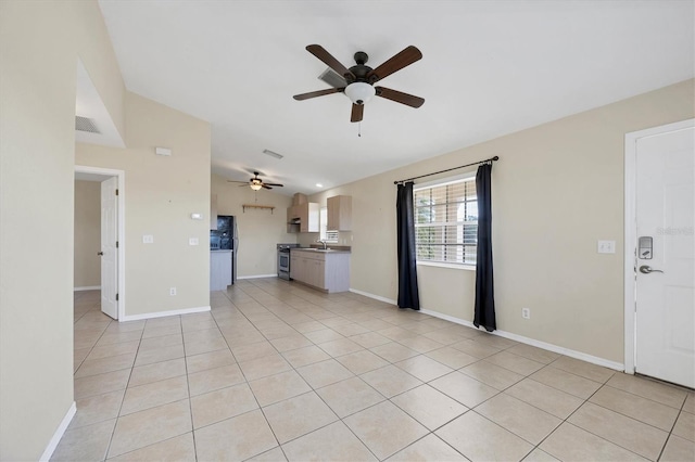 unfurnished living room with light tile patterned flooring, vaulted ceiling, sink, and ceiling fan