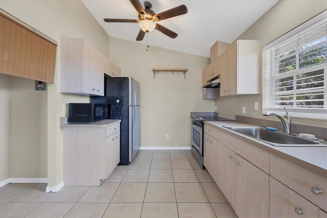 kitchen featuring light tile patterned flooring, light brown cabinetry, sink, vaulted ceiling, and appliances with stainless steel finishes