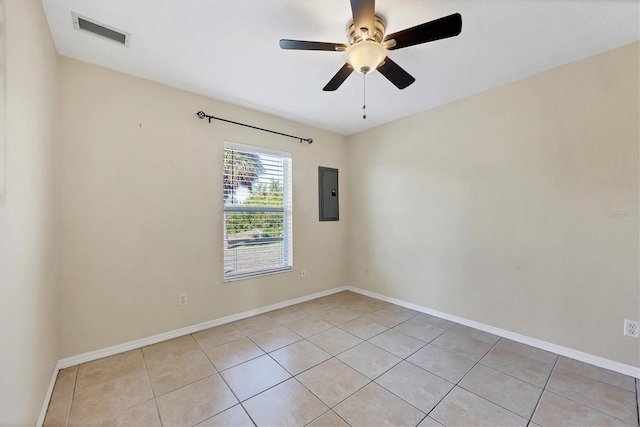 tiled empty room featuring ceiling fan and electric panel