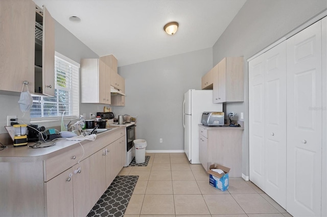 kitchen with light tile patterned floors, range with electric cooktop, and light brown cabinets