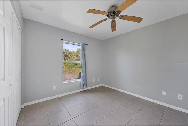 empty room featuring ceiling fan and light tile patterned floors