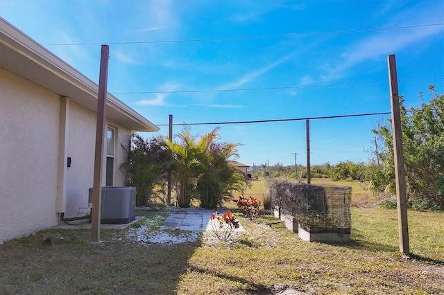 view of yard with central AC unit and a patio area