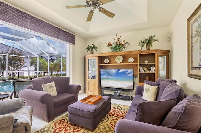 tiled living room featuring a raised ceiling and ceiling fan